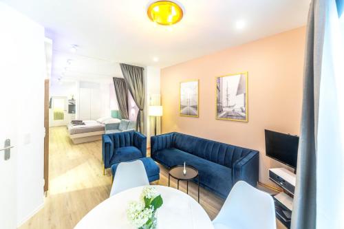 ein Wohnzimmer mit einer blauen Couch und einem Fernseher in der Unterkunft Altstadt Studio Papenstraße in Stralsund