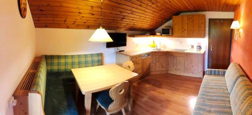 a kitchen with a wooden table and a dining room at Greobenlehen in Marktschellenberg