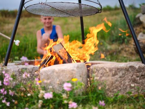 a woman sitting in front of a fire at Mayr-Hof (Mank) in Seimetzbach