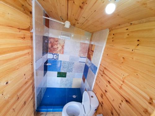 W drewnianym pokoju znajduje się łazienka z toaletą. w obiekcie Skyline Glamping Guasca w mieście Guasca