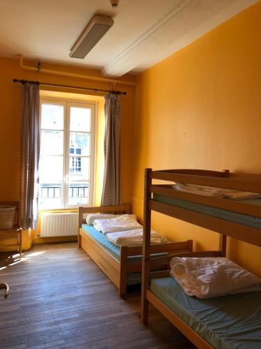 um quarto com 2 beliches e uma janela em Hostellerie des Grands Chapeaux em Bayeux