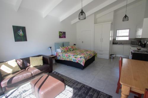 a living room with a couch and a bed at Pine Park Garden Cottages in Johannesburg