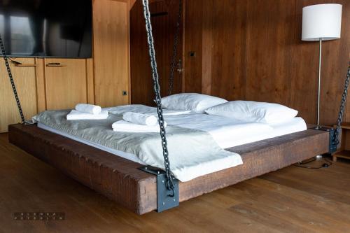 a swing bed with white pillows on it at Vinica Castle Boutique & Spa Hotel in Vinica