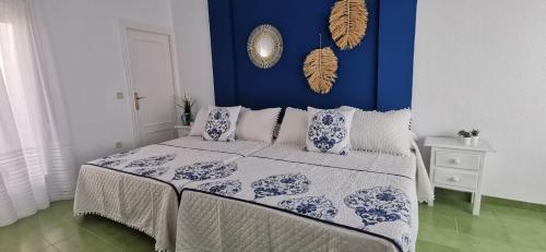 una camera da letto blu e bianca con letto e cuscini di La Buganvilla Beach House a Calahonda