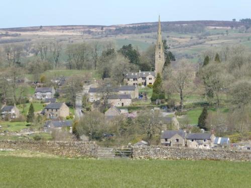 a village with a church and a stone wall at Black Lion Inn in Leek