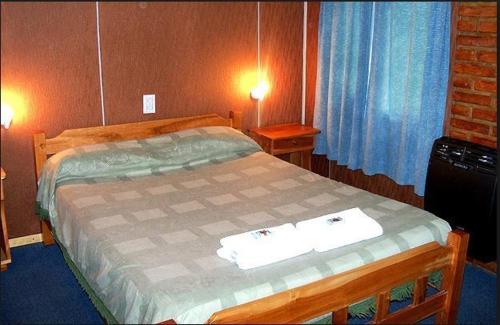 a bedroom with a bed with two towels on it at Complejo Los Arrayanes in San Carlos de Bariloche