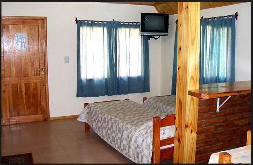 um quarto com uma cama e uma televisão na parede em Complejo Los Arrayanes em San Carlos de Bariloche