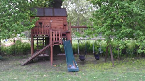 a wooden playground with a slide and a slideintend at Orange-Ville Lodge & Guesthouse in Stellenbosch