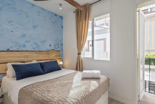 ein Schlafzimmer mit einem Bett und einer blauen Wand in der Unterkunft Apartment Gaudi in Sitges