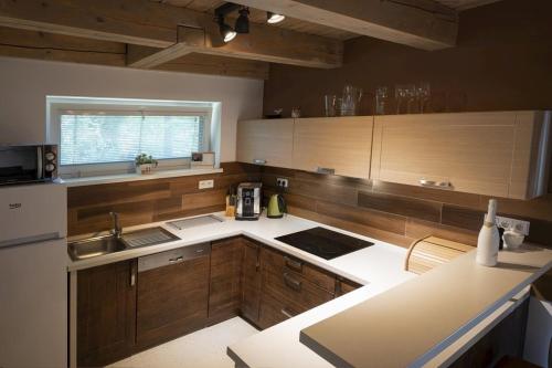 a kitchen with wooden cabinets and white counter tops at Chata Emily in Smižany