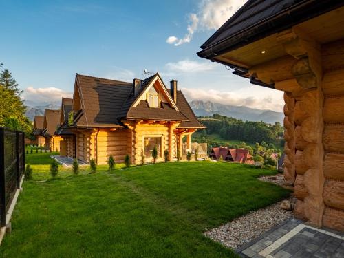 a house with a green lawn in front of it at Osada Bachledzki Wierch Odkryj Zakopane in Zakopane