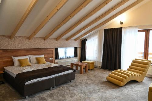 ein Schlafzimmer mit einem Bett und einem Stuhl in einem Zimmer in der Unterkunft Magnolija Resort Ponikva in Kočani