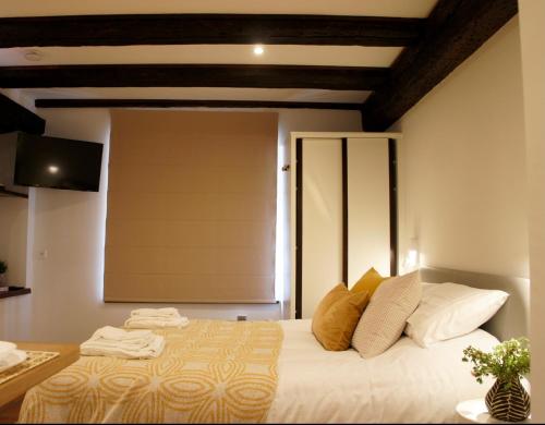 een slaapkamer met een bed met witte lakens en kussens bij La Cour du Vignoble in Kaysersberg