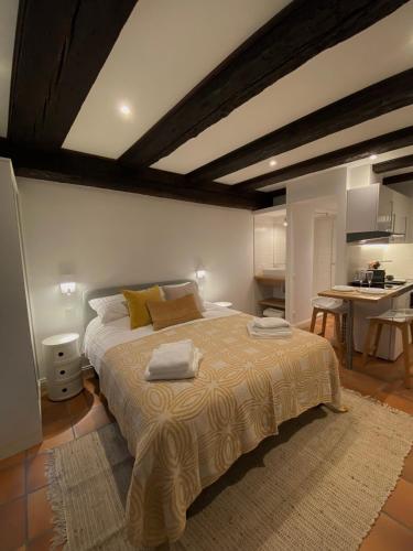 une chambre avec un grand lit et une cuisine dans l'établissement La Cour du Vignoble, à Kaysersberg