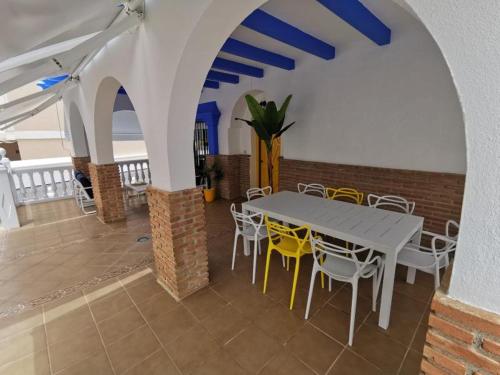 una sala da pranzo con tavolo e sedie di La Buganvilla Beach House a Calahonda
