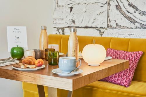 a wooden table with a coffee cup and pastries on it at Les Jardins de Coppélia in Pennedepie