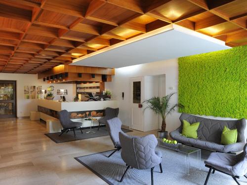 a living room with chairs and a green wall at Garni Hotel Schmaus in Viechtach