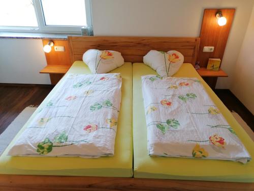 
two beds with white comforters and pillows on them at Peterseil's Radl Zimmer in Mauthausen
