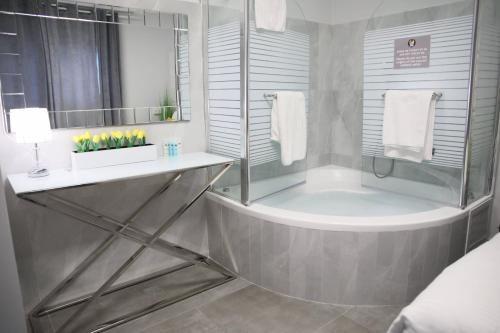 a bathroom with a shower and a tub with a sink at Miami Beach Hotel Tel Aviv in Tel Aviv