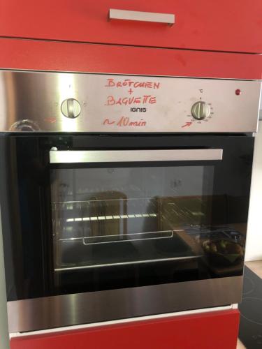 a microwave oven in a kitchen with a red cabinet at Babsi Appartments - leben am Land in Wels