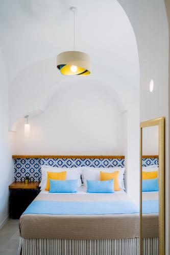 a bedroom with a bed with blue and orange pillows at Monte Brusara Relais in Ravello