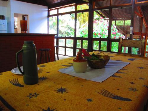 a table with a yellow table cloth with a vase on it at Acqua Jungle Glamping & Room in Abraão