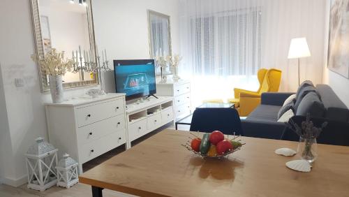 a living room with a television and a table with a bowl of fruit at Apartament Mare , Rewal ulica Szczecińska 21 Apartament nr 3 in Rewal