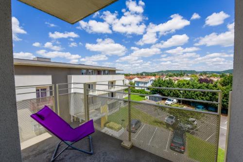 a purple chair on a balcony with a view at Résidence Columba - Apparts meublés Agen Sud in Agen
