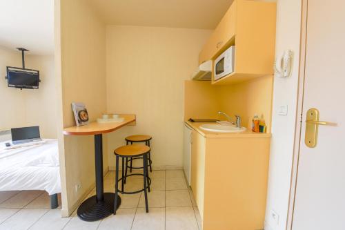 a small room with a sink and a table at Résidence Columba - Apparts meublés Agen Sud in Agen