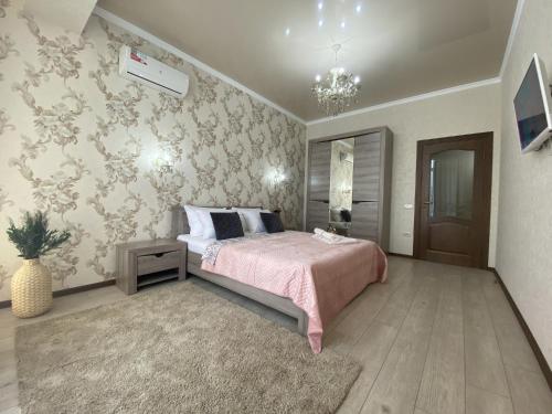 a bedroom with a bed with a pink comforter at Квартиры Le Majestic Lux возле Парка by Sutki26 in Pyatigorsk