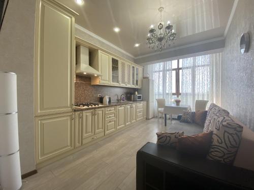 a living room with a couch and a kitchen at Квартиры Le Majestic Lux возле Парка by Sutki26 in Pyatigorsk