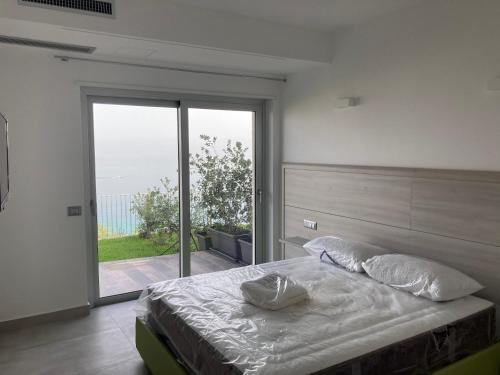 een slaapkamer met een bed en een glazen schuifdeur bij Residenza Timpa Janca in Vibo Valentia Marina