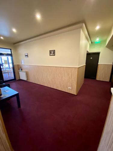 an empty room with a red carpet and a wall at Pensiunea Rix Rooms in Focşani