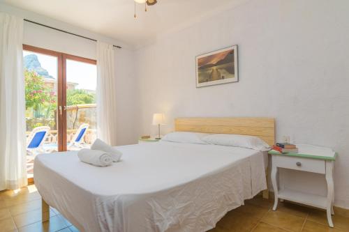 a bedroom with two beds and a table and a window at Can Clavell in Artá