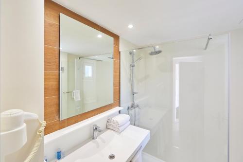 een badkamer met een wastafel en een spiegel bij OLA Apartamentos Cala d'Or in Cala d´Or