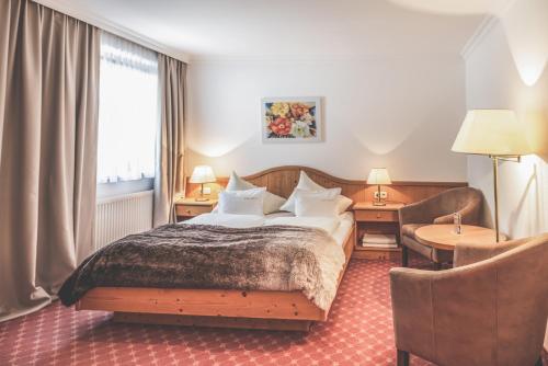 a hotel room with a bed and a chair at Kertess in Sankt Anton am Arlberg
