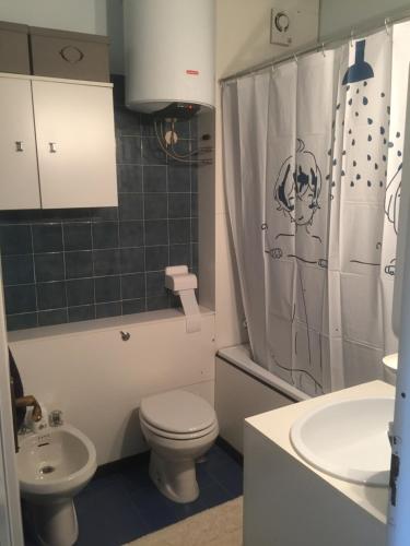 łazienka z toaletą, umywalką i zasłoną prysznicową w obiekcie 1° RESIDENCE GARESSIO 2000 w mieście Borgo Ponte