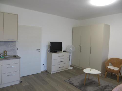 een woonkamer met een tv en een dressoir met een televisie bij Éva Apartmanház 3 in Csopak