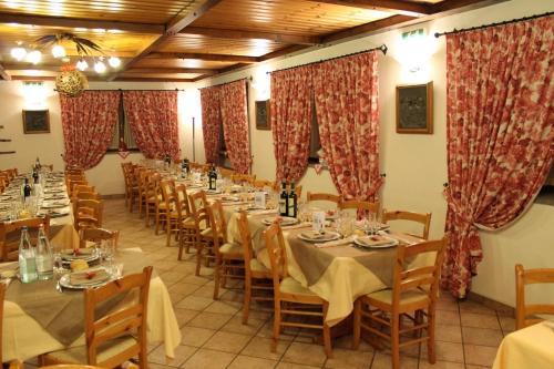 a row of tables in a room with red curtains at Hotel Mont Nery in Challand Saint Anselme