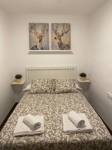 a bedroom with a bed with two towels on it at Apartamento Corazón de Cazorla by Clabao in Cazorla
