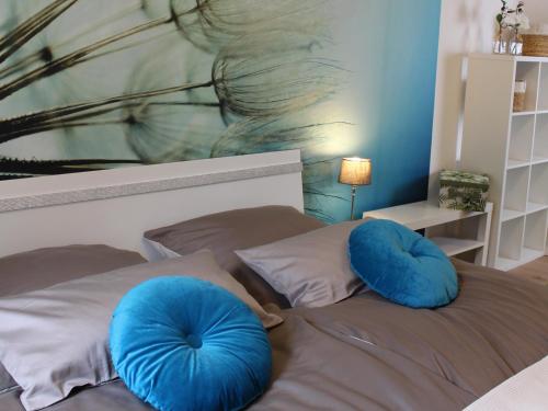 a bedroom with blue pillows on a bed with a painting at Ferienwohnung Küsterland in Assinghausen