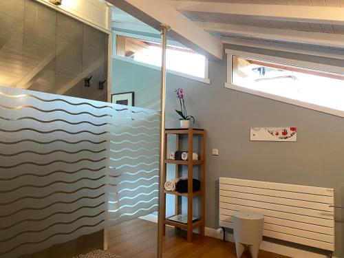 La salle de bains est pourvue d'une fresque murale représentant des vagues. dans l'établissement Chambre des Chenets, à Samoëns