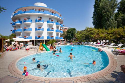 un gruppo di persone in una piscina accanto a un hotel di Hotel Playa Blanca a Duna Verde