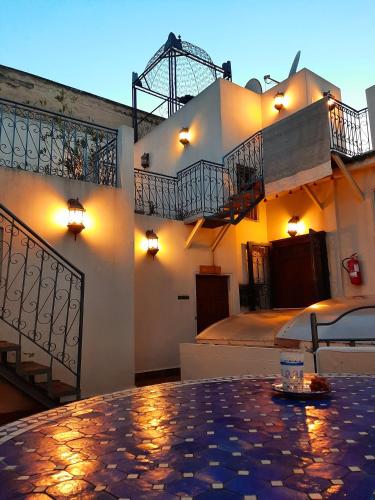 a building with two balconies and a table in a room at Dar Abdesalam in Fès