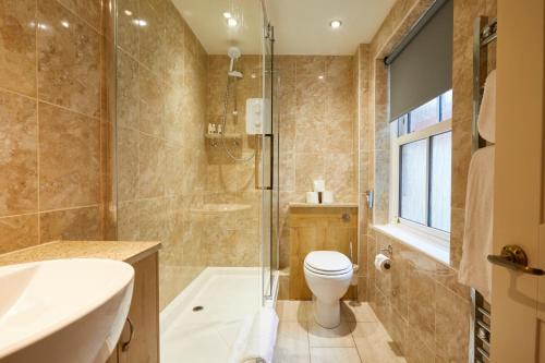 a bathroom with a toilet and a shower and a sink at The Quarrymans Arms in Corsham