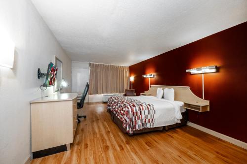 a hotel room with a bed and a desk at Red Roof Inn & Suites Wytheville in Wytheville