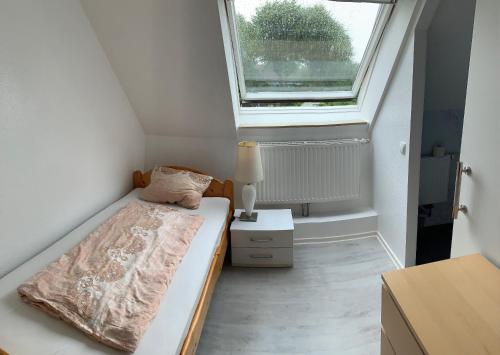 a small bedroom with a bed and a window at Pension A1 Stuckenborstel in Sottrum