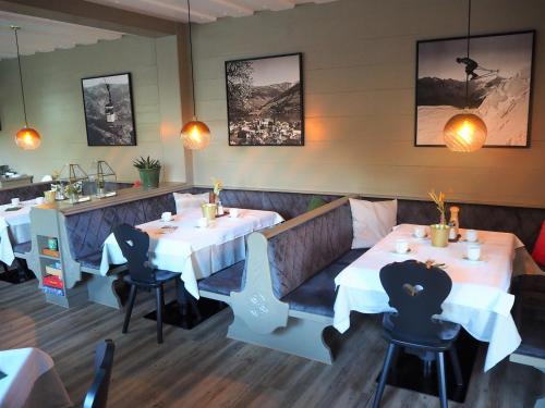 a restaurant with two tables and chairs in a room at Pension Margarete in Zell am See