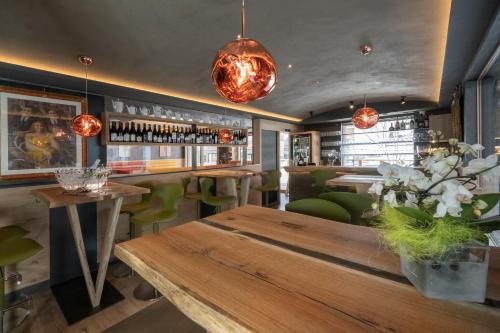un ristorante con tavolo in legno e sedie verdi di Locanda degli Artisti Art Hotel a Canazei