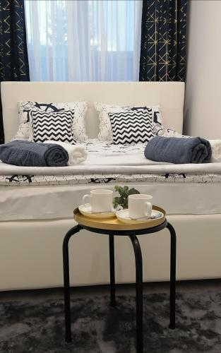 łóżko z dwoma kubkami na stole w pokoju w obiekcie Apartament Portowy w mieście Wilkasy